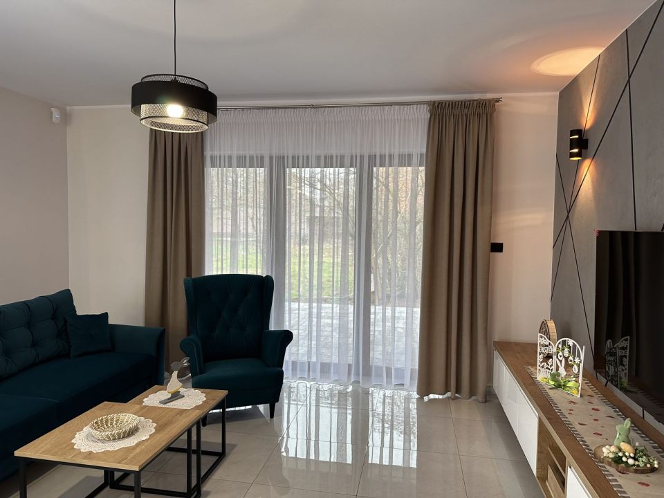 Living room with kitchen with delicate beige curtains and drapes